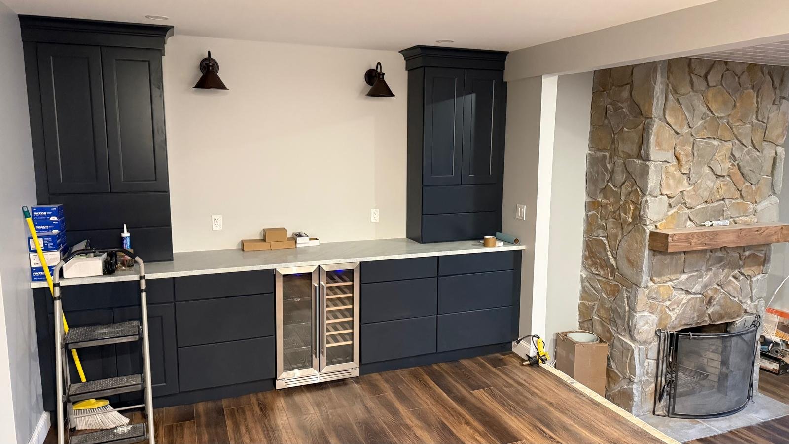 Custom dark navy cabinetry with stone fireplace