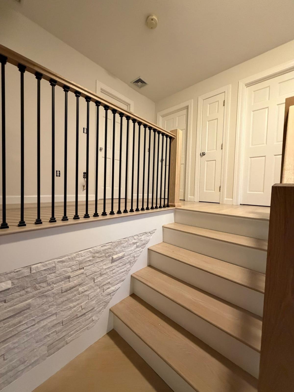 Custom staircase landing with stone accent wall